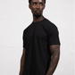 A man wearing a black Suna Cotton® Adult T-shirt