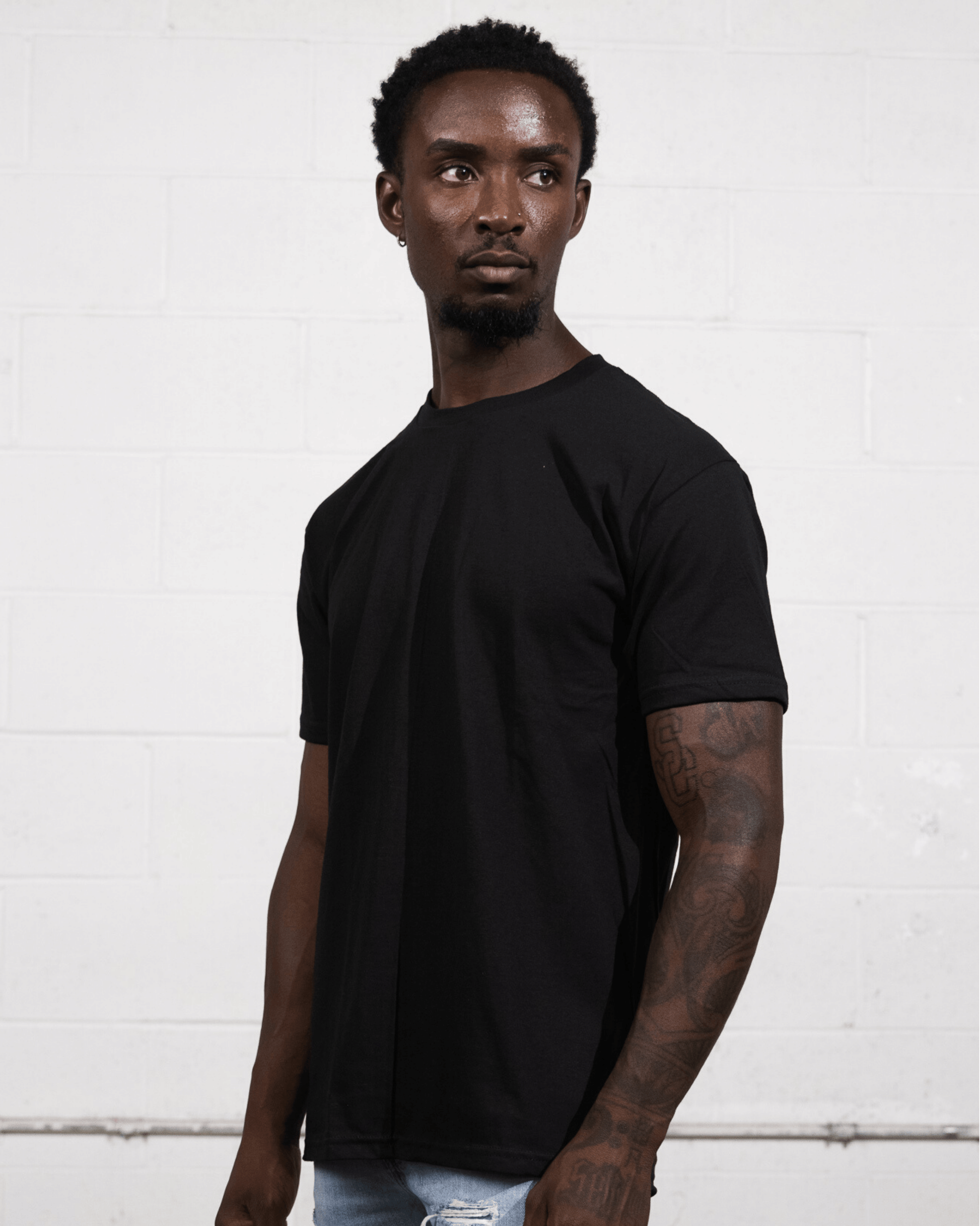 A man wearing a black Suna Cotton® Adult T-shirt