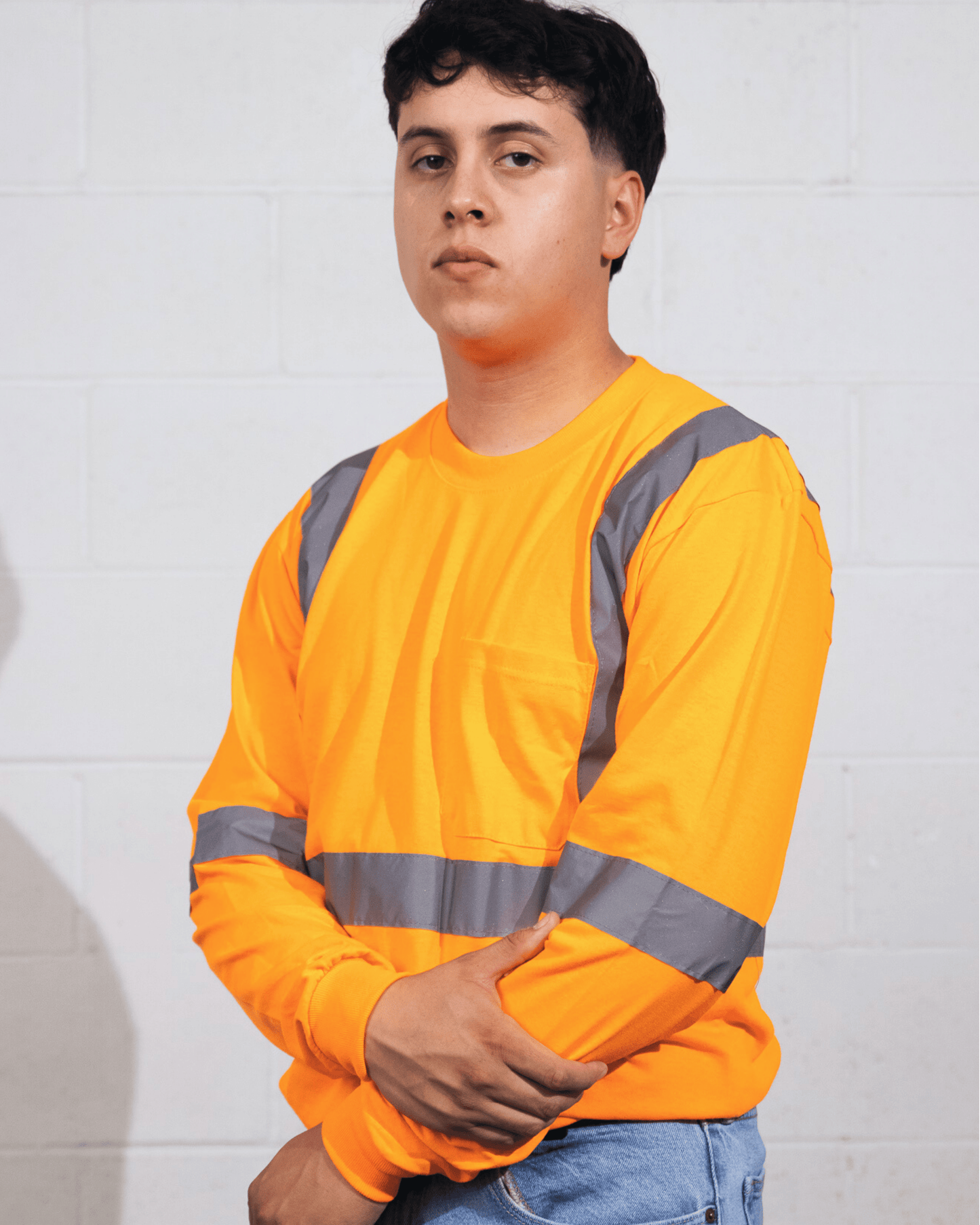 Man wearing a Suna Cotton® Safety Orange Long Sleeve Reflective T-shirt