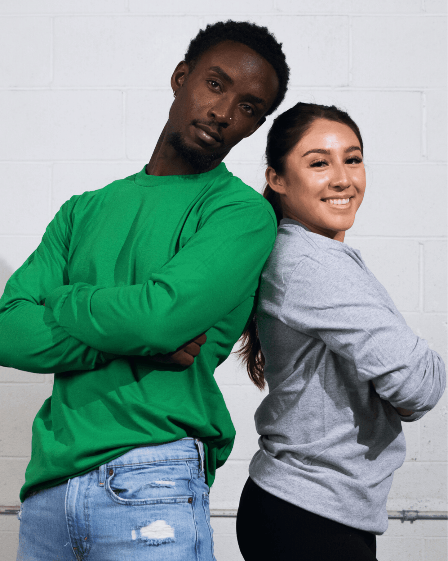 A man and woman wearing Suna Cotton® Long Sleeve T-shirt in green and heather grey.